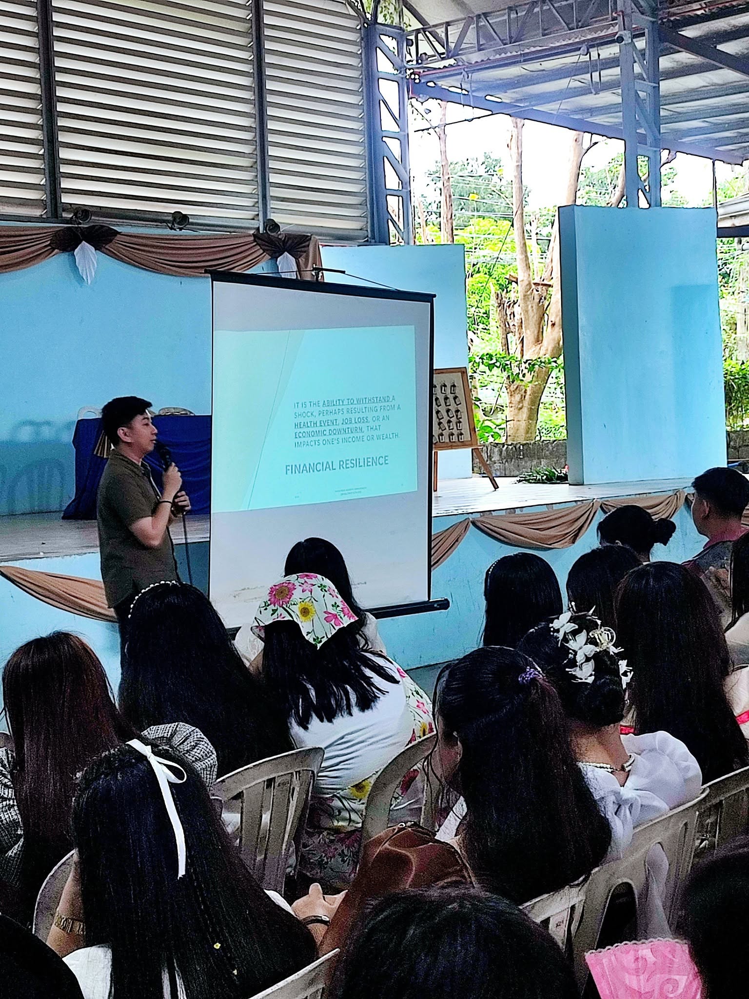 Jayson presenting a Financial Resilience slide to seated students at the College of Mary Immaculate