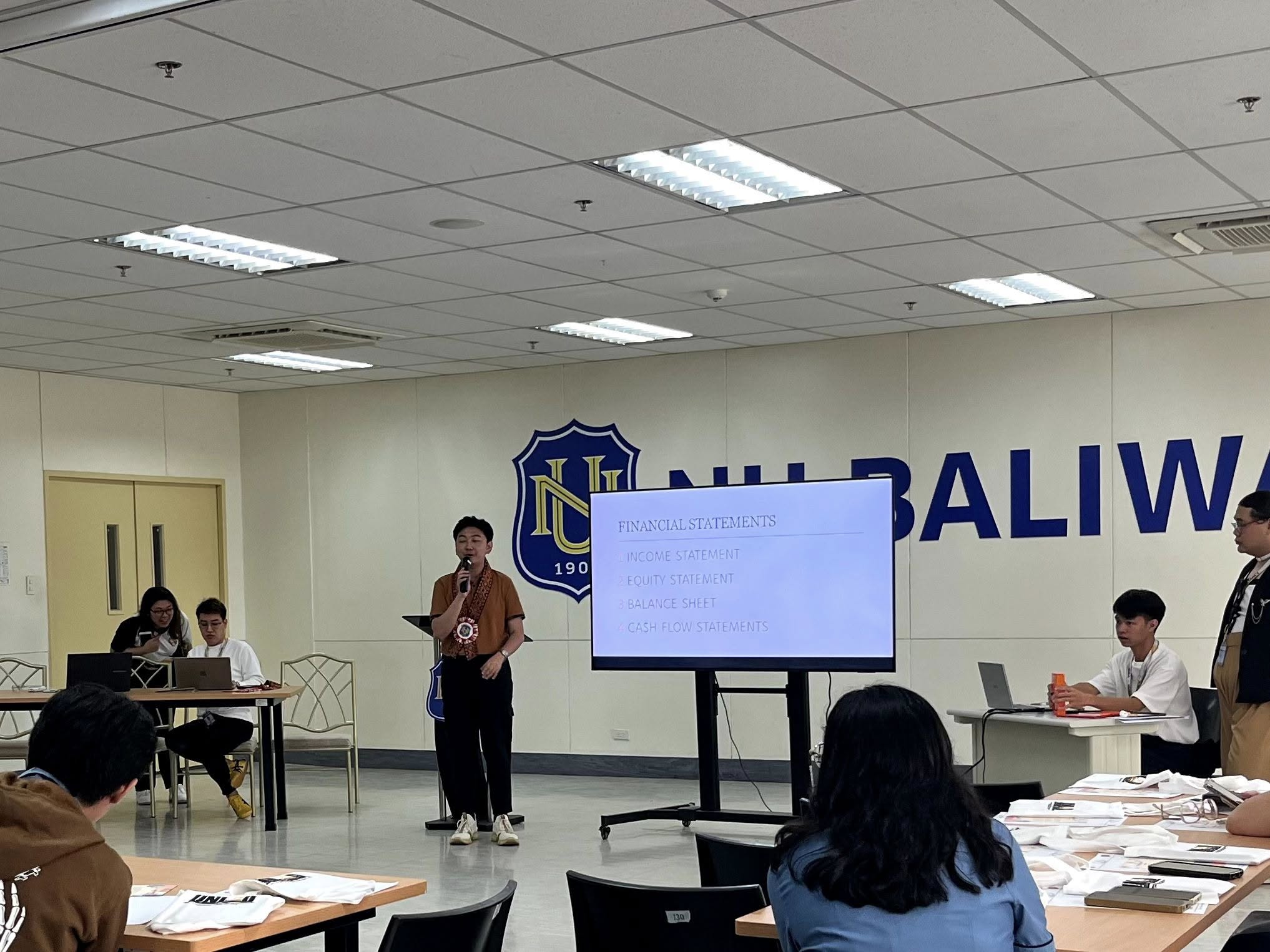 Jayson presenting a Financial Statements slide to seated entrepreneurs at National University – Baliwag