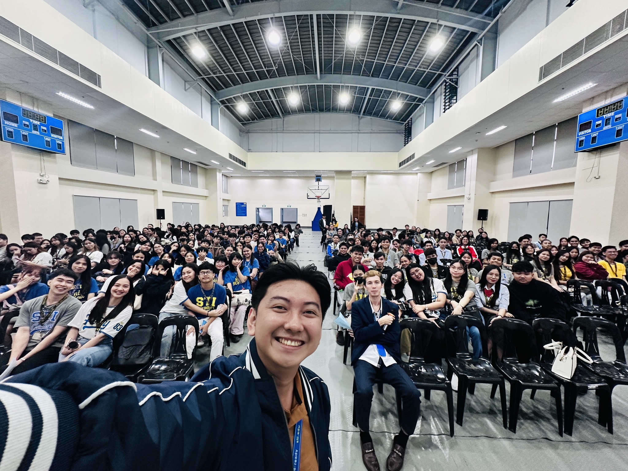 Jayson taking a wide selfie with the full student audience during the STI College Project Kaagapay tax seminar